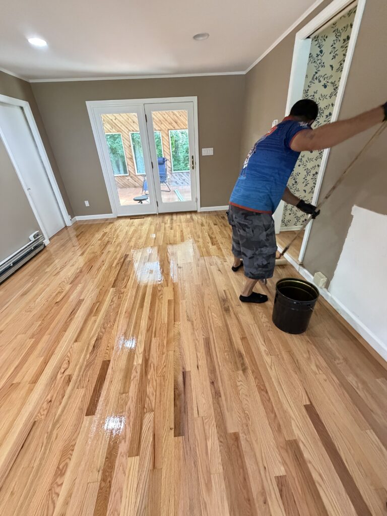 Professional hardwood floor refinishing in progress, sanding worn wood floors to restore their natural beauty.
